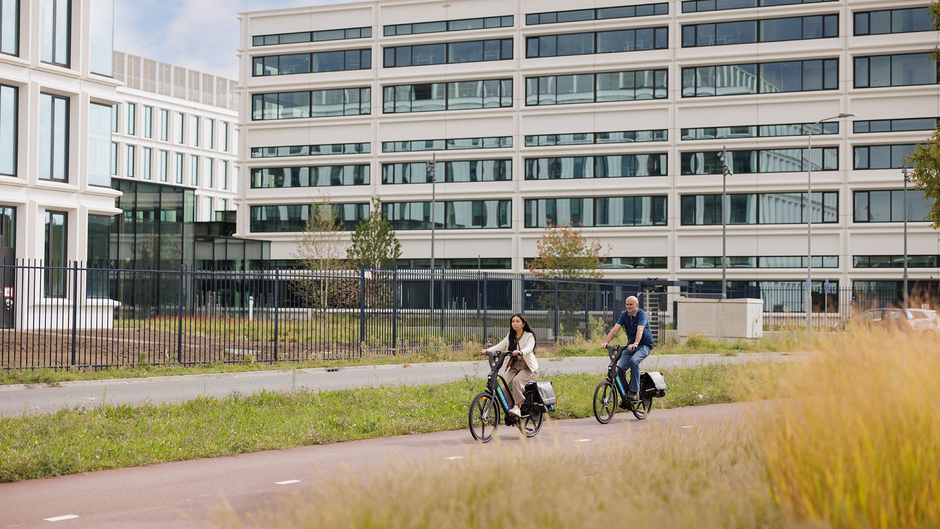 People cycling past an ASML building