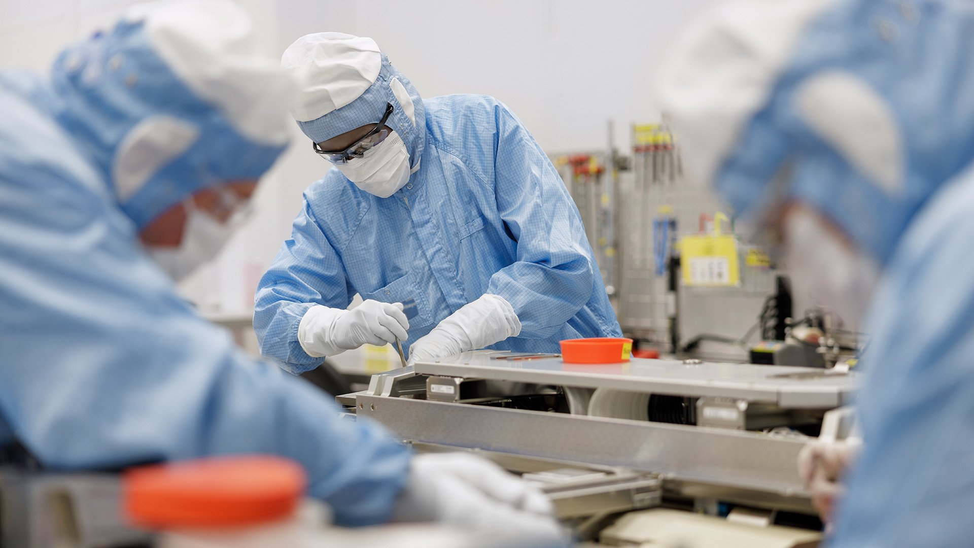 Technicians assembling equipment in a cleanroom