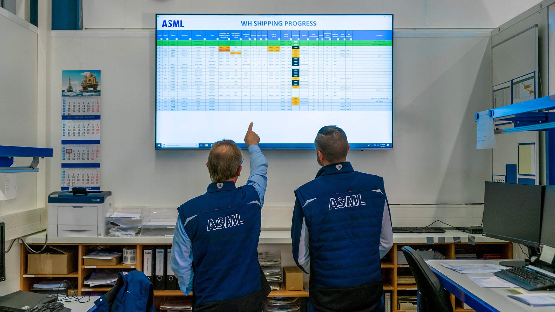 ASML employees reviewing information on a screen